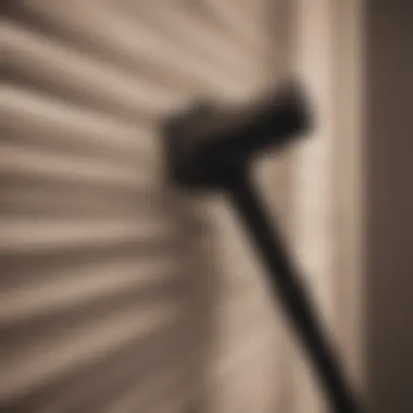 A person using a vacuum cleaner attachment on pleated blinds