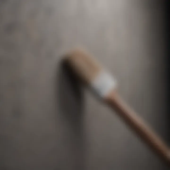 Close-up of a brush applying paint on a textured wall